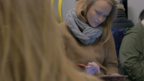 young woman using tablet computer in subway train