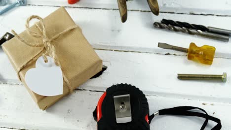 caja de regalos con herramientas de trabajo y equipo de pesca en tabla de madera