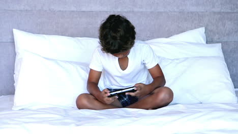 un niño pequeño sentado en la cama.