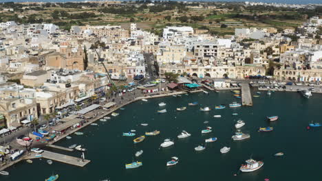 aerial view over fishing village of marsaxlokk in malta - drone shot