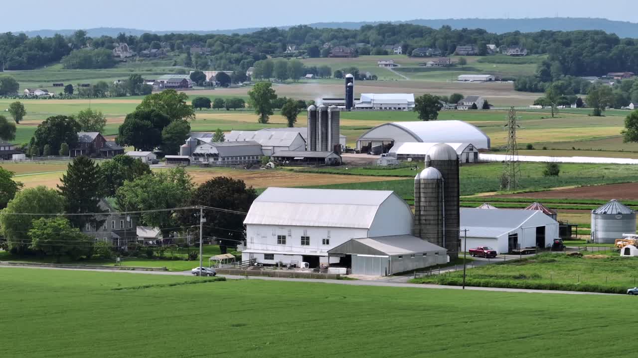 Cars on rural interstate road along American farmsteads. Aerial wide shot. Sunny day in American suburb. Establishing shot.