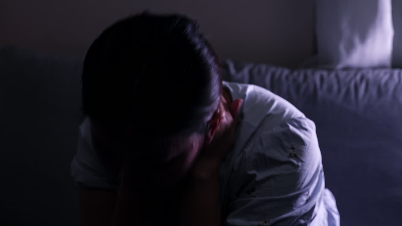 una mujer sola en una habitación oscura está llorando sus ojos en desesperación, frustración, y muchas emociones contradictorias