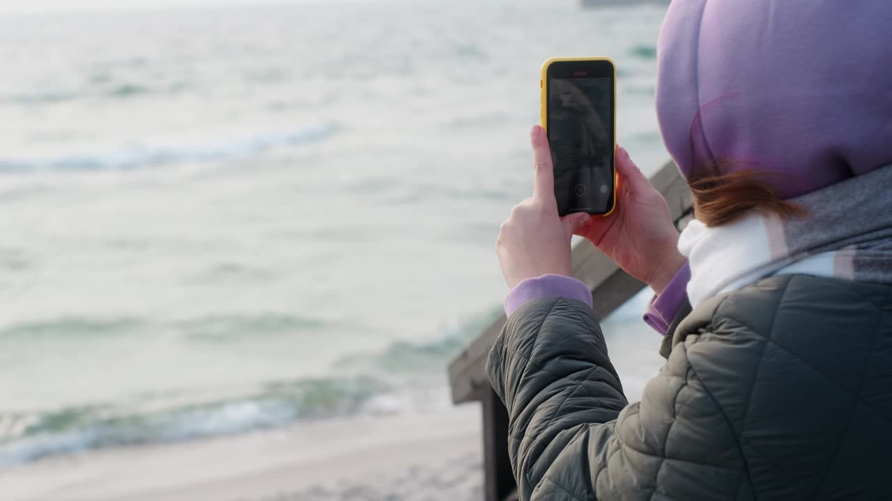 Woman taking a picture of the sea
