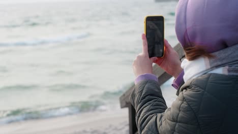 woman taking a picture of the sea