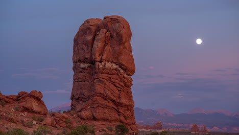 Lapso-De-Tiempo-De-La-Puesta-De-Sol-Y-La-Luz-De-La-Luna-Sobre-El-Parque-Nacional-De-Arcos-De-Formación-Rocosa-Equilibrada,-Utah-Usa,-Cielo-Azul-Y-Luna-Creciente