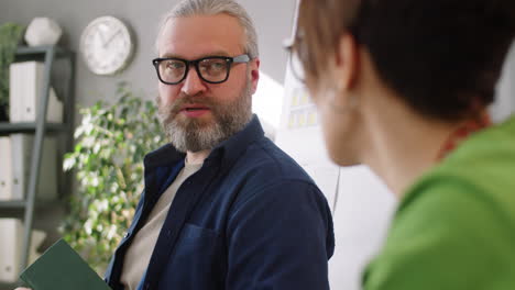 senior businessman speaking with female colleague