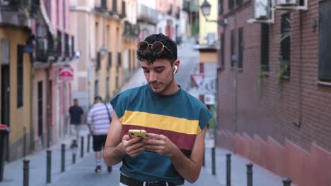 young caucasian man with long false nails choosing a song with his phone.