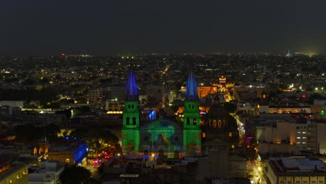 catedral de guadalajara illuminated by vibrant light projections celebrating jalisco traditions and cultural icons at aluzinante light sow. dolly in nighttime aerial