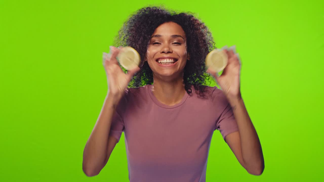 African female is taking halves of yellow lemons and makes glasses from it