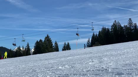 view on a ski lift with skiing people in the foreground