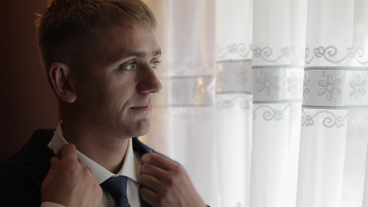Handsome groom fixes his jacket. Wedding morning. Businessman. Slow motion