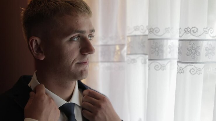 Handsome groom fixes his jacket. Wedding morning. Businessman. Slow motion