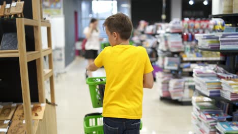 kid in shopping mall. boy choosing stationery in the supermarket
