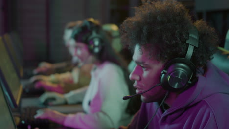 close up of an cybersport gamer playing video games with his friends in a gaming club