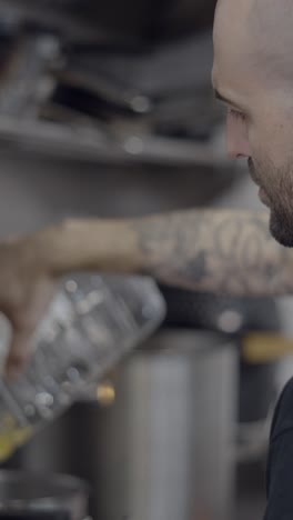 person pouring liquid from a bottle during cooking