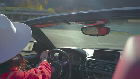 woman driving a convertible car on a scenic route