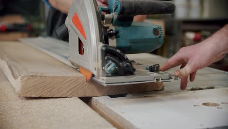 slow motion. the master cuts a wooden board with a circular saw in the woodworking workshop of a small furniture manufacturer. v4