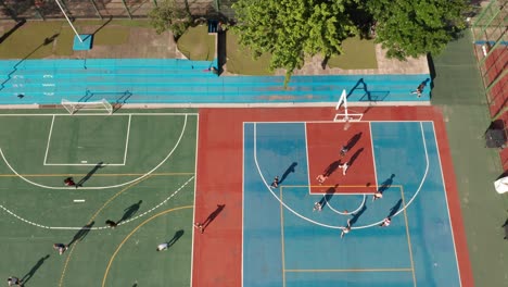 campo deportivo con atletas jugando baloncesto y fútbol en los respectivos campos