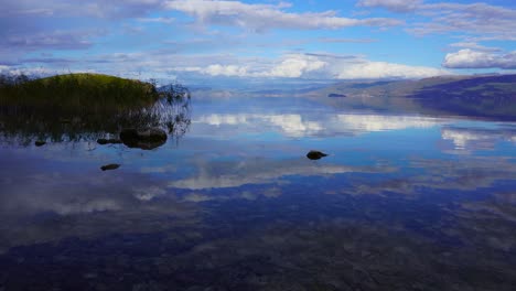 superficie de agua de espejo tranquila que refleja un hermoso cielo con nubes en colores azules en el crepúsculo