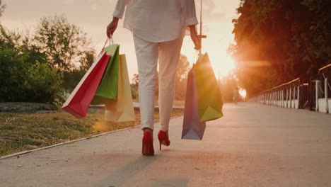 a woman in red shoes carries shopping bags