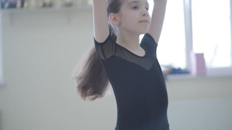 joven bailarina en la lección de estudio. rendimiento de entrenamiento. postura de ejercicio de estiramiento. bailarina practica técnica de equilibrio. elegancia clásica fitness.