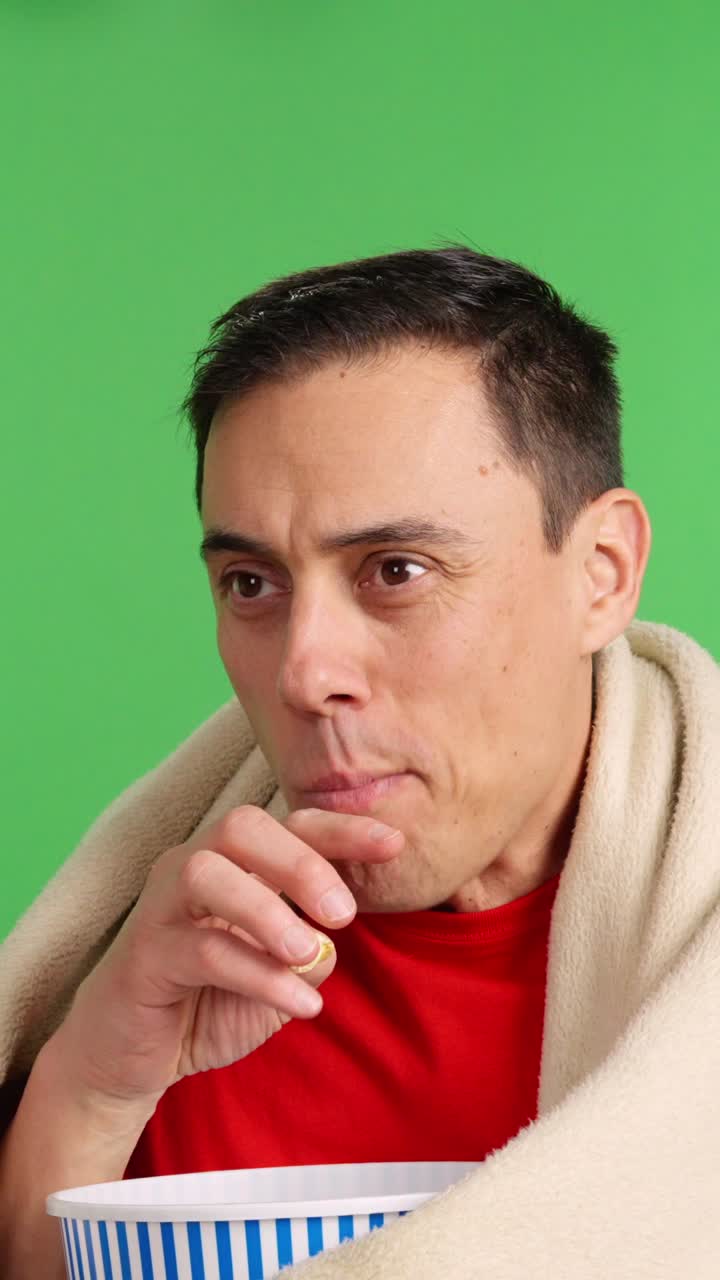 Man watching tv and eating popcorn on green screen background