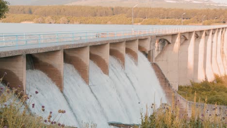 water pouring out over the spillways of a dam