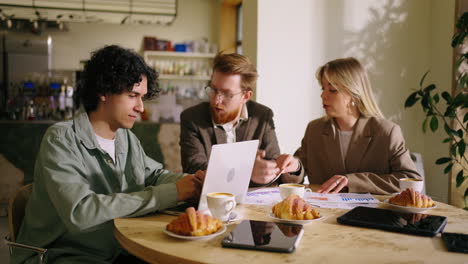 three young professionals having a business meeting at a cafe