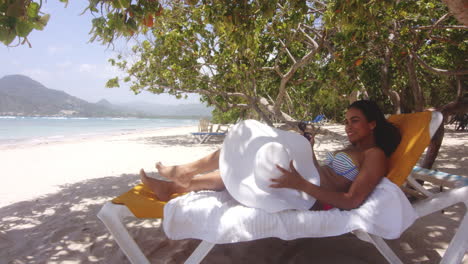 latino dominican lady gets up from sun lounger on tropical beach resort playa teco maimon