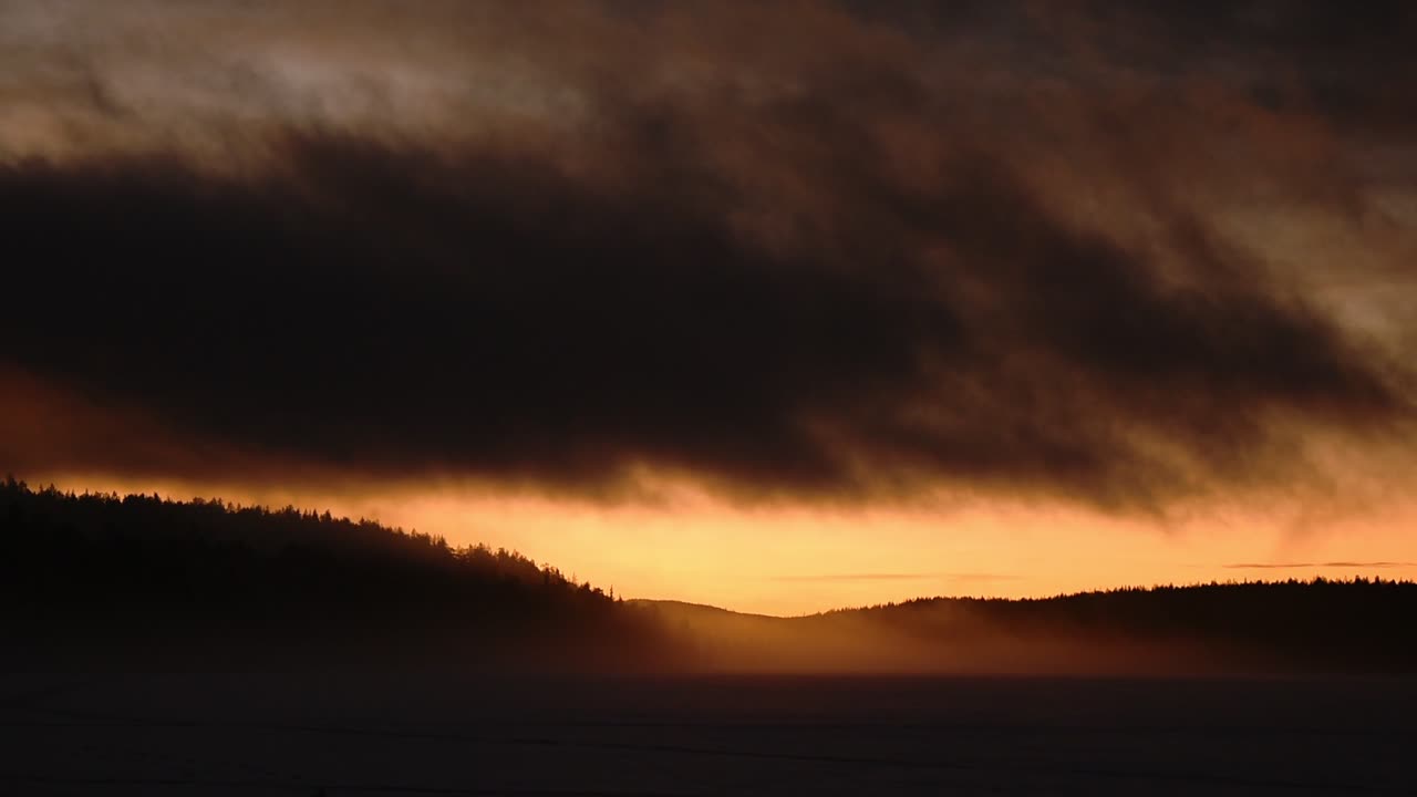 The stunning view of the sunset over the dark land of Lapland, Finland during the evening