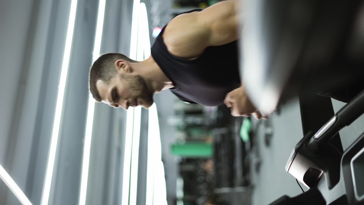 hombre deportivo corriendo en una máquina de correr mientras entrenaba cardio en el club de gimnasia