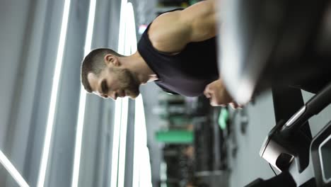 Sport-man-running-on-treadmill-machine-while-cardio-training-in-gym-club