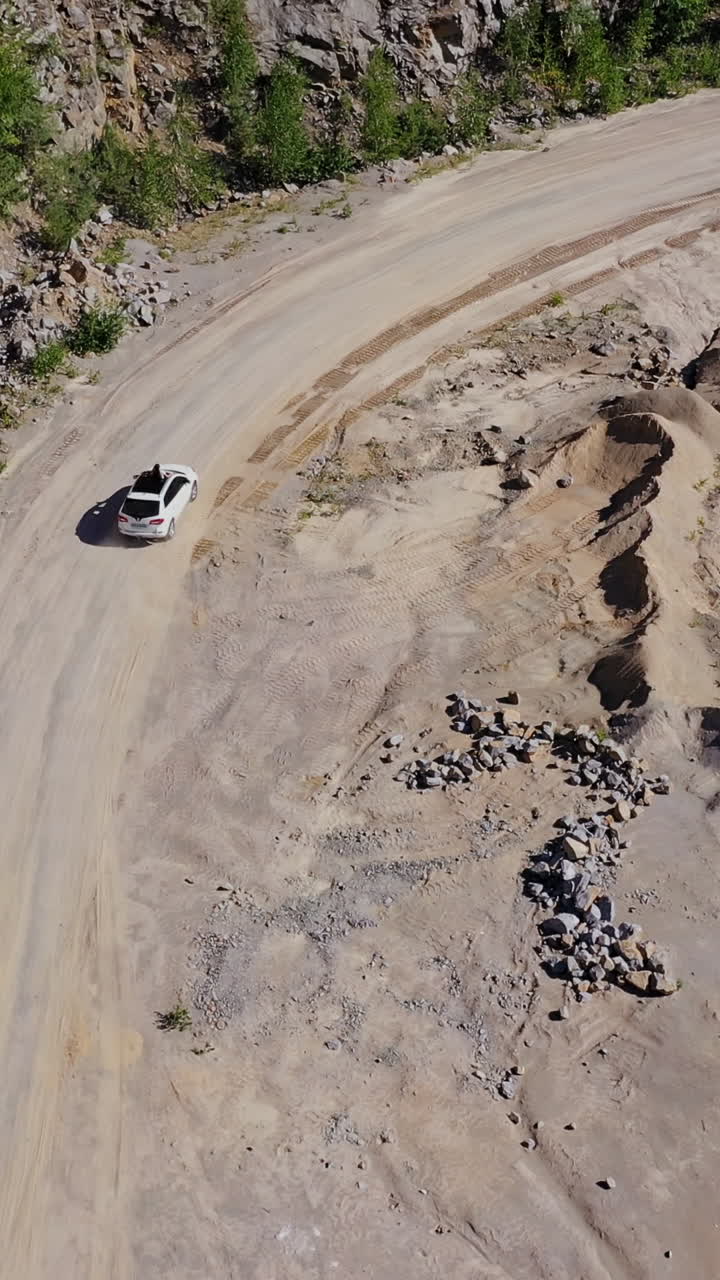 Car driving near lake. View of the road near lake and mountain from above. Vertical video