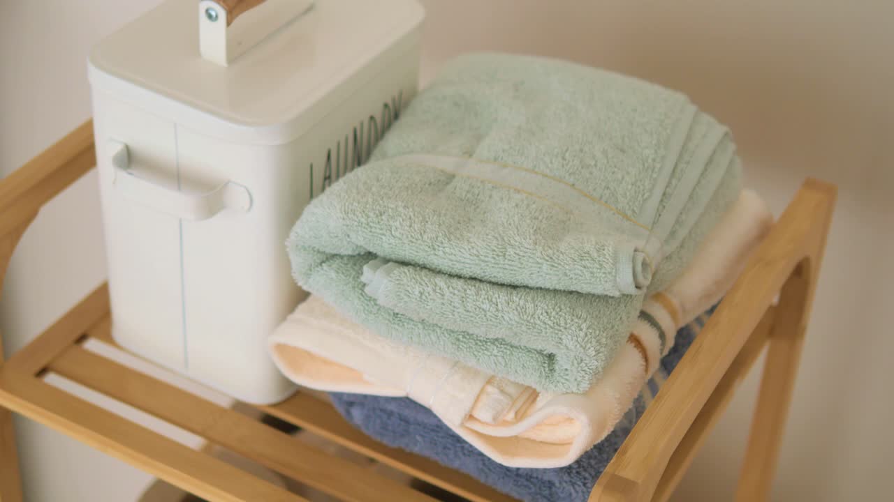 Folded Towels and Laundry Basket on a Wooden Shelf