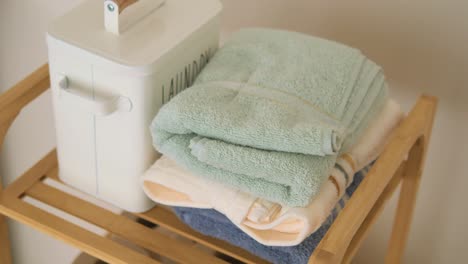 folded towels and laundry basket on a wooden shelf
