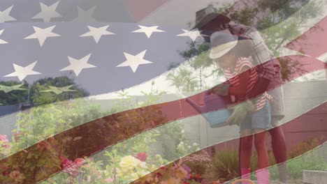 animación de la bandera de los estados unidos de américa sobre un padre y una hija afroamericanos que hacen jardinería