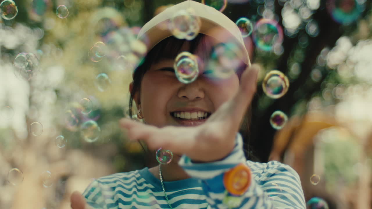 Smiling child playing with soap bubbles outdoors, joyful moment in natural light