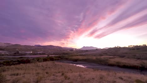 colorful cloudscape over a mountain landscape - town nestled in an idyllic valley time lapse