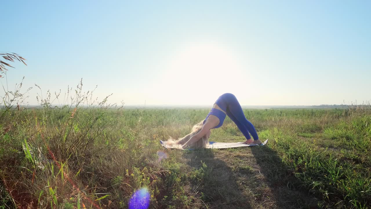Woman practicing yoga outdoors in a field