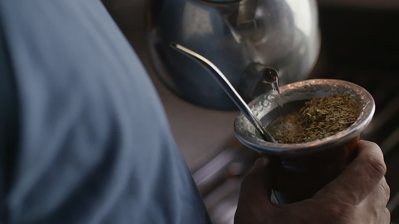 Close up of traditional Argentine mate being served with hot water in a gourd