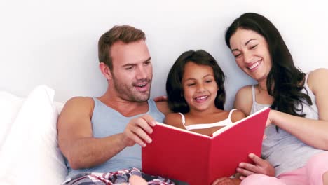 Nette-Familie,-Die-Ein-Buch-Auf-Ihrem-Bett-Liest