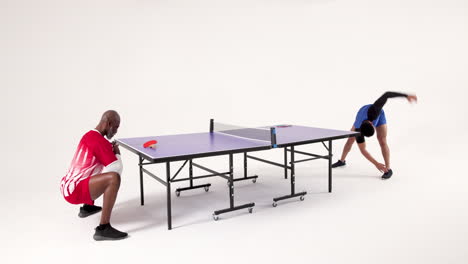 playing table tennis, two men competing intensely in studio setting