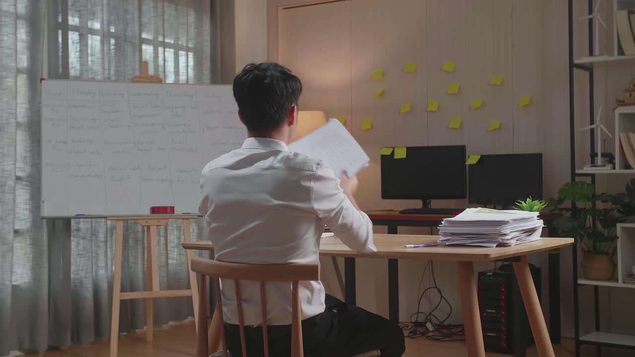 사무실에서 문서 작업을 마치고 축하하는 행복한 아시아 남자의 뒷면