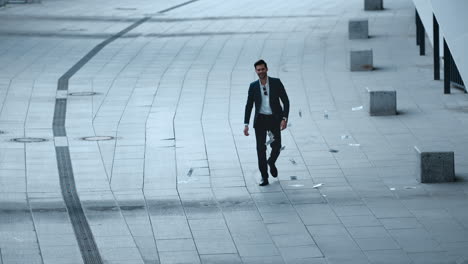 un homme d'affaires confiant qui jette de l'argent dans la rue, un homme d'affaires qui marche en ville.