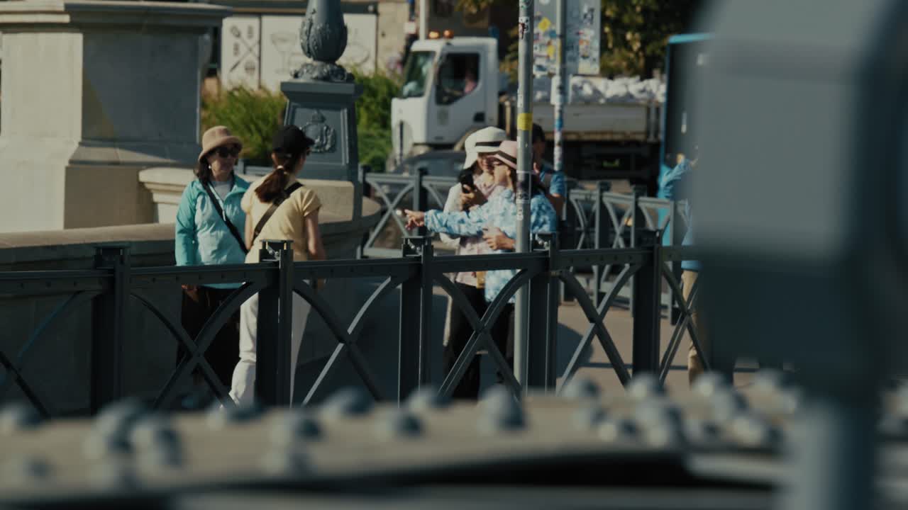 Tourists taking photos on a bridge near a historic site in Budapest during the Budapest Flood 2024