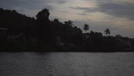 A-beautiful-view-of-residential-houses-on-the-river-bank-in-the-woods---an-evening-with-clouds-on-sky