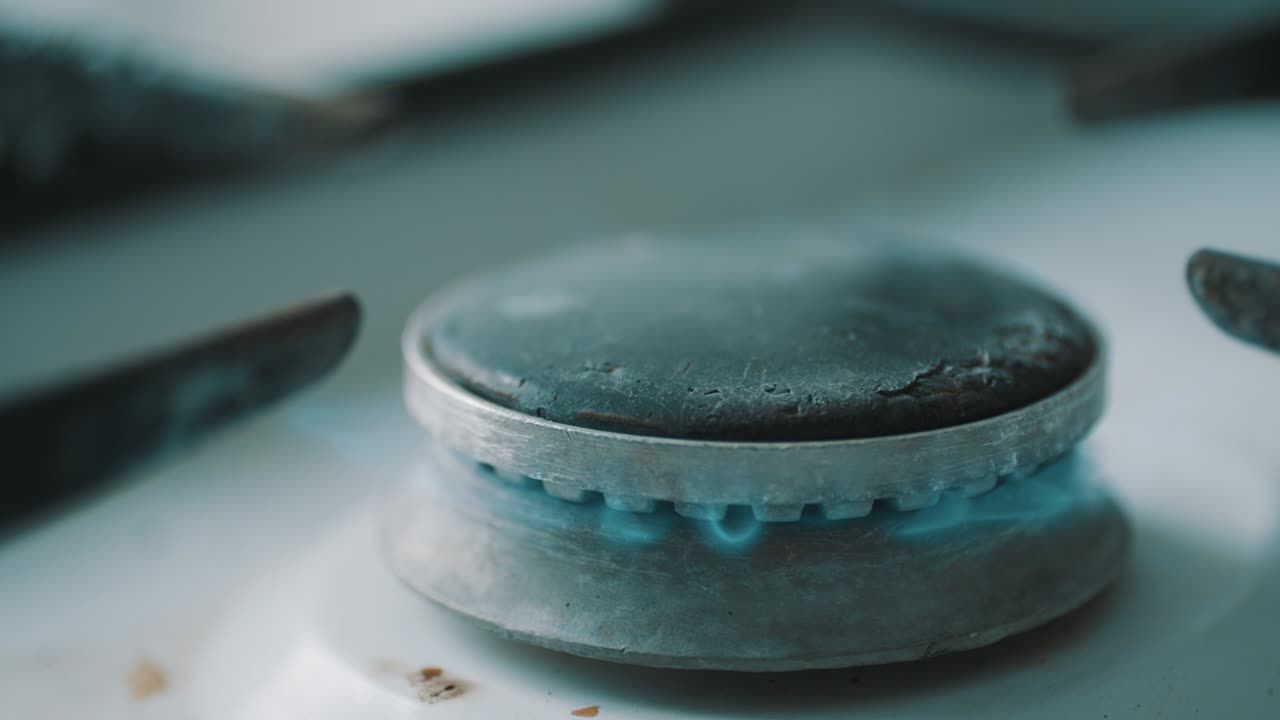 스토브 버너가 파란색 요리 불꽃으로 불타고 있습니다.