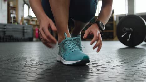 front view low section of an athletic caucasian woman tying her shoelaces