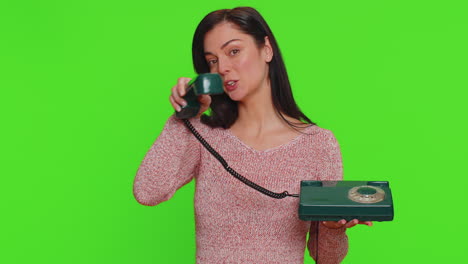 Young-woman-talking-on-wired-vintage-old-fashioned-retro-telephone-of-80s,-says-hey-you-call-me-back