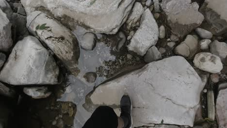 person hiking through a rocky stream